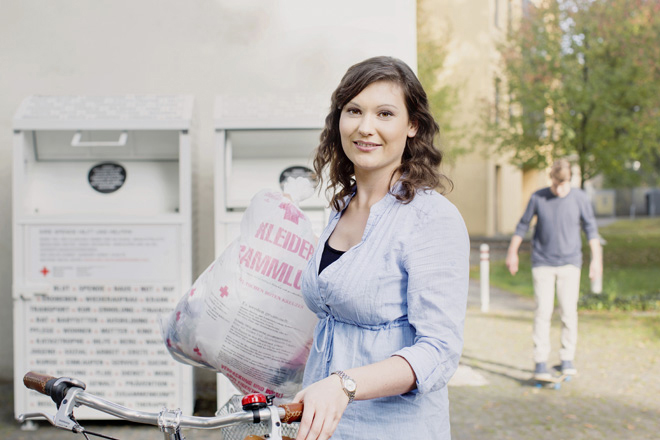 Kleidersammlung des DRK und Altkleidercontainer: junge Frau mit Altkleidersack vor einem Container des DRK- 2014 Kleidersammlung des DRK und Altkleidercontainer: junge Frau mit Altkleidersack vor einem Container des DRK- 2014